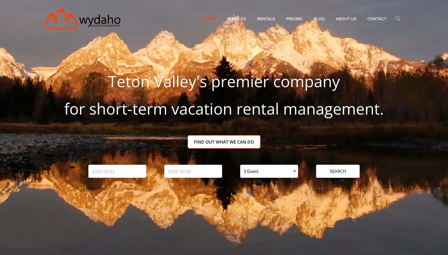 Landing page of a vacation rental business with search fields and a mountain range background